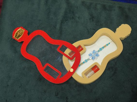 A blue flower style Rakhi with bottle style packaging Exclusive